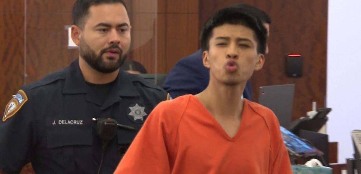 Teen accused of ‘retaliation’ murder of man whose stepdaughter rejected his advances blows kisses in court as victim’s family looks on